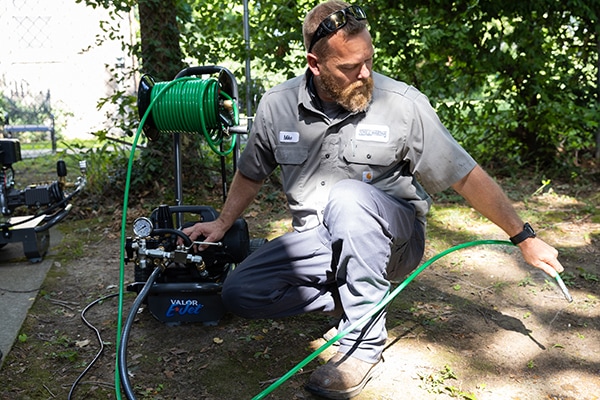 Mike M. performing hydro jetting outside.