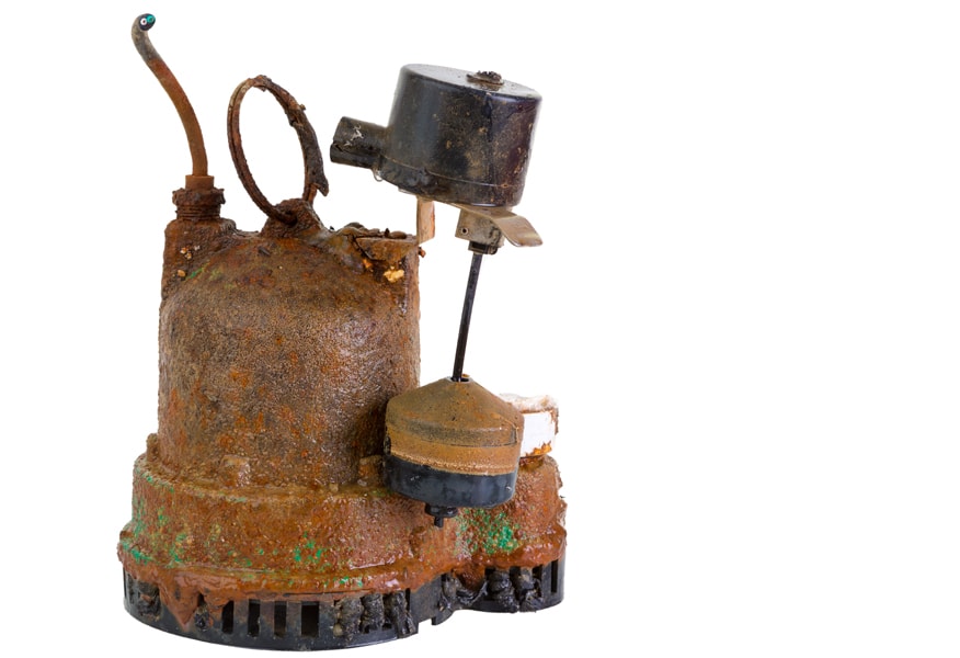 Old defunct, obsolete, grungy, rusted sump pump that has been removed for replacement due to malfunction or breakdown.