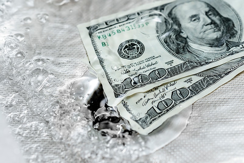 5 Plumbing Problems Costing You Money. Money washing down the drain.