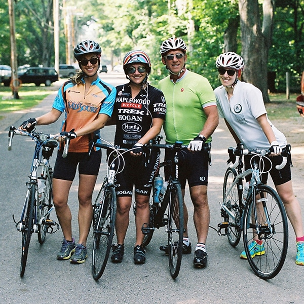 Tony LaMartina with his daughters riding bikes outside on a sunny day.