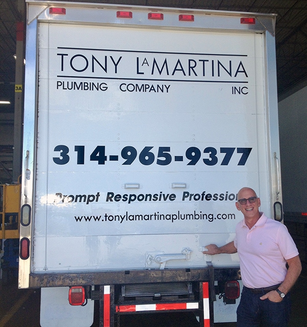 Tony LaMartina wearing a pink polo and standing at the back of a white Tony LaMartina Plumbing Company truck.